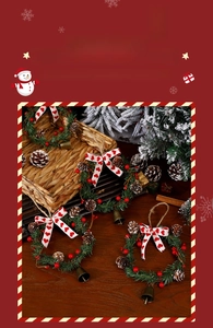 Close-up of Christmas wreath set with pine cones, red berries and bronze bell