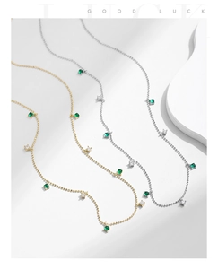 Close-up of gold and silver beaded necklaces with emerald crystals and white zircons