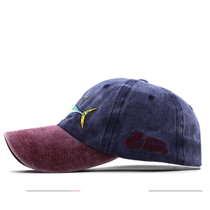 Detail of vintage washed cotton baseball cap with embroidered shark and anchor motifs