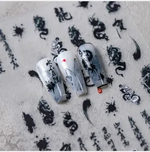 Macro shot of ink dragon nail stickers and calligraphy details on long coffin nails