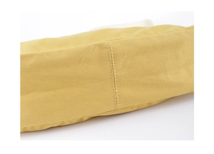 Detailed macro view of yellow canvas bag stitching and reinforced bottom fabric texture