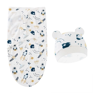 Close-up of baby swaddle and hat set with space rocket and planet pattern on white cotton