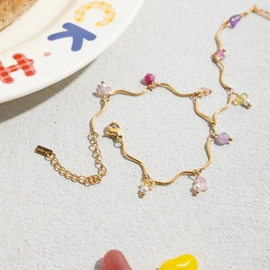 Detail of 18k gold plated stainless steel bracelet with natural colorful stones and pearls