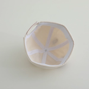 Detailed interior of beige baby brimless hat with reinforced seams and adjustable strap