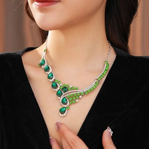 Detail of vintage silver necklace with green pear-shaped rhinestones on a model