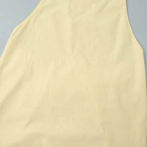 Détail du haut sans manches jaune clair montrant le coton de qualité et la texture lisse