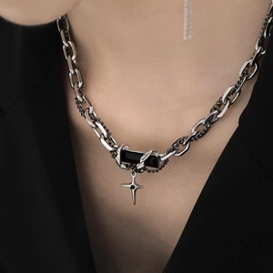 Silver chain necklace with black stone and star pendant worn on a black suit jacket