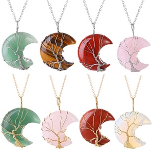 Detalle de colgantes de ágata natural en forma de luna con árbol de la vida sobre cadenas
