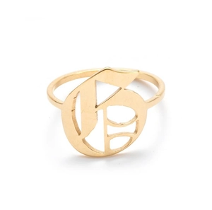 Detail shot of vintage golden stainless steel ring with gothic uppercase letter G engraving