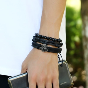 Multilayer leather braided bracelet with tree of life charm and black beads on wrist