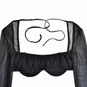 Detailed back view of black glitter crop top with sheer sleeves and tie-up ribbon design