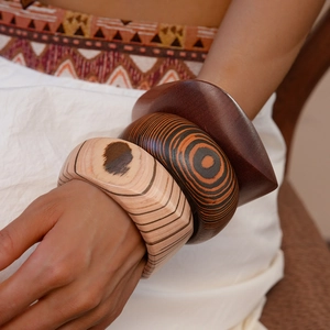 Detailed close-up of three vintage wooden cuff bracelets with diverse grain patterns