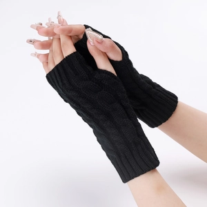 Close-up of black cable-knit fingerless arm warmers showing texture and thumb hole