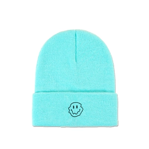 Detailed view of the mint blue knit beanie featuring a melting smiley face embroidery