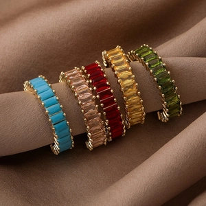 Detail of five adjustable metal rings with colorful square zircons on brown silk