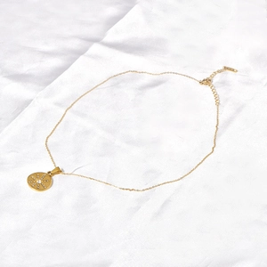 Vintage 18K gold stainless steel necklace with sunburst zircon pendant on white silk