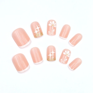 Faux ongles courts carrés rose nude avec pointes blanches french et fleurs pailletées or