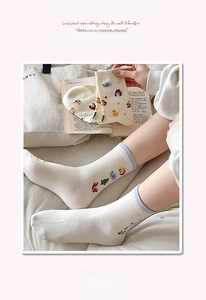 Détail de chaussette en coton blanc avec broderie ours et bord-côte rayé bleu clair