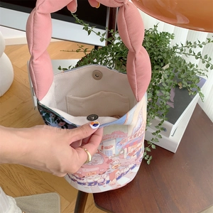 Detail of canvas bucket bag interior with magnetic clasp and cute cartoon print