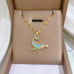 Golden dolphin necklace with blue enamel, white zircons and pearl on champagne box