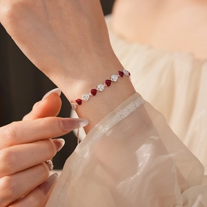 Close-up of elegant red enamel and zircon heart bracelet on a woman wrist