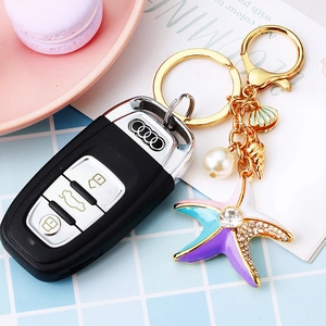 Starfish and pearl keychain with gold sea shell charms on a car key, nautical style