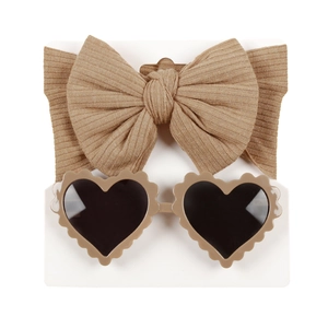 Infant khaki knitted bow headband and heart-shaped sunglasses set on display card