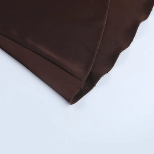 Detailed macro view of high-quality brown satin fabric stitching and hemline sewing