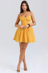 Detailed close-up of vibrant yellow lace floral pattern and structured corset bodice