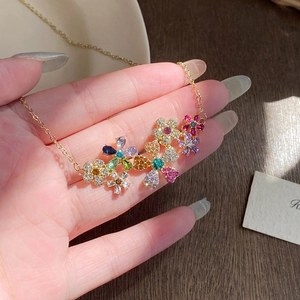 Détail d'un collier pendentif fleur en strass colorés avec une chaîne dorée élégante