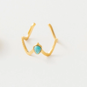 Detailed macro of gold drop turquoise ring featuring an adjustable crown-shaped band