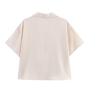 Back view of light apricot short sleeve shirt with minimalist resort style coconut embroidery