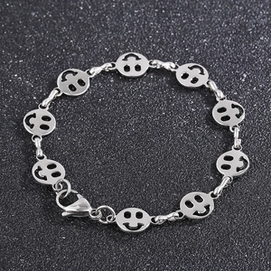 Macro detail of silver titanium steel chain featuring hollow smile face charms and clasp