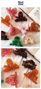 Detail view of various french acetate checkered bow claw clips with metal springs