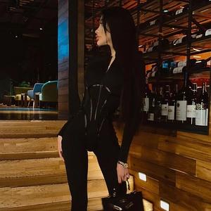 Detail eines schwarzen Sport Bodysuits mit Konturlinien und Frontreißverschluss Design