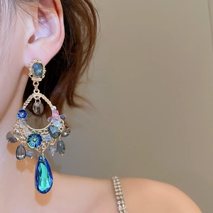 Macro shot of vintage bohemian earrings with blue crystal teardrops on a model