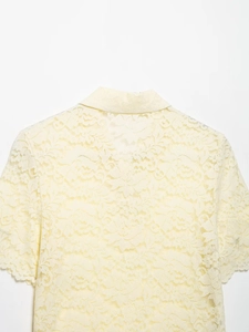 Detailed back view of a light yellow short-sleeved lace shirt with floral patterns
