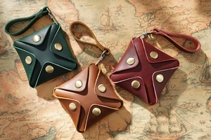Three leather mini coin purses in green, brown, and red on a vintage map background
