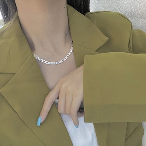 Close-up of elegant silver flat hollow link chain necklace worn on a fashion model