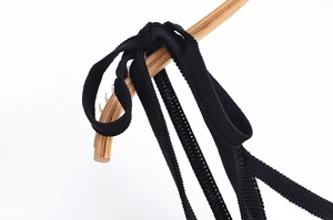 Gros plan sur la texture de la bretelle noire tricotée pour les détails de la robe