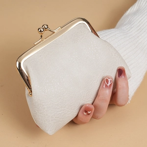 Close-up of off-white lychee texture leather coin purse with golden kiss-lock frame
