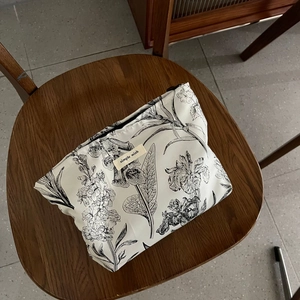 Detail shot of vintage jacquard makeup bag with black floral patterns and brand label