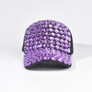 Dettaglio degli strass viola scintillanti sulla visiera di un cappello da baseball nero