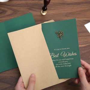 Vintage dark green greeting card with gold stamping and metal flower in kraft envelope
