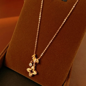 Macro detail of gold-plated clover pendant with cubic zirconia on velvet stand
