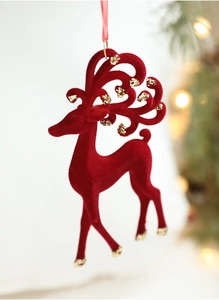 Detail of red flocked reindeer Christmas ornament with gold sequins on a holiday tree