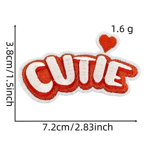 Macro detail of 'CUTIE' embroidered patch with heart, size 7.2x3.8cm in orange and white