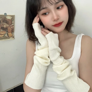 Detail showing the cream white knitted texture and stacked style of the long arm sleeves