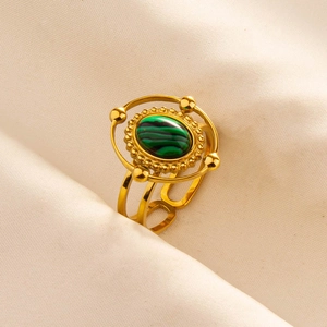 Detailed macro of gold ring featuring a malachite stone inlay and ornate double-band design