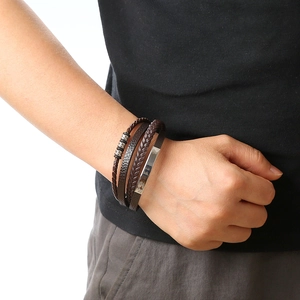 Detail of multi-layer brown braided leather bracelet with metal beads on male wrist